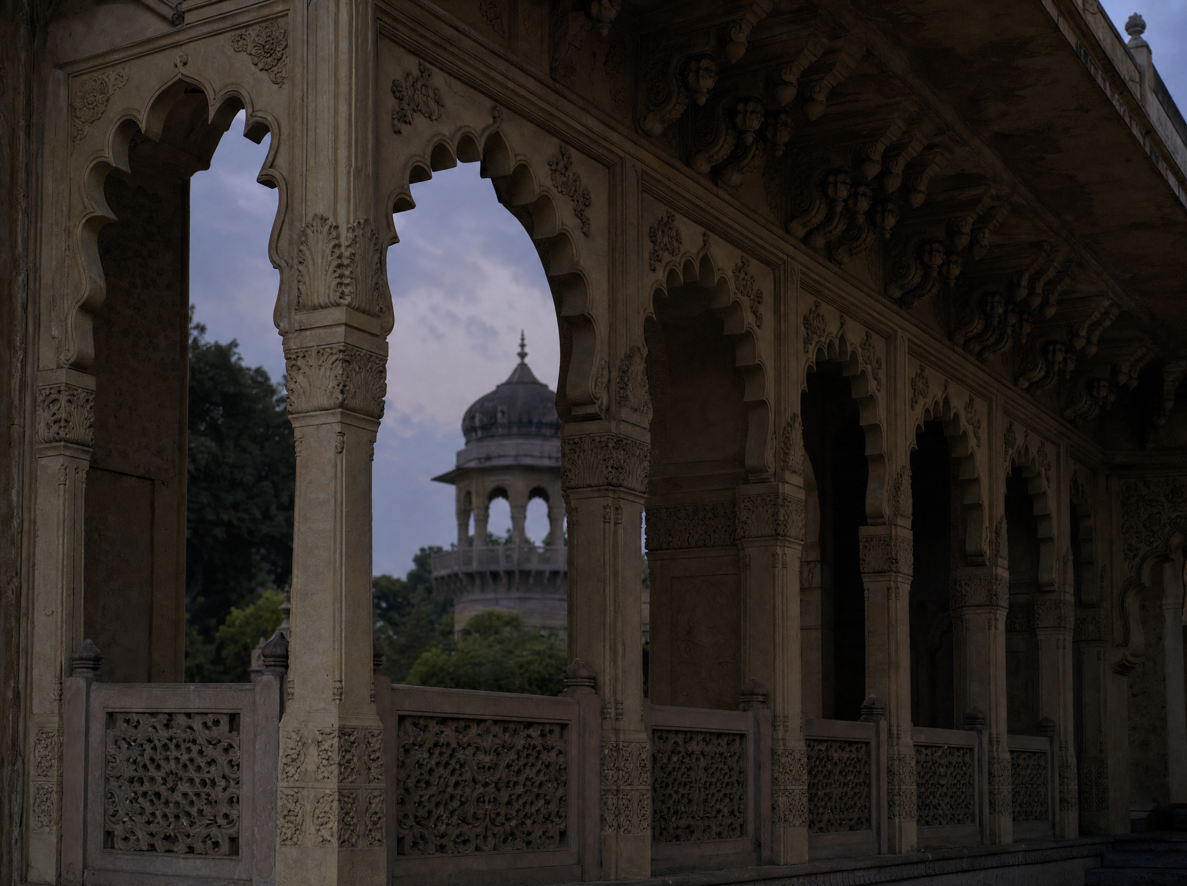The carved sandstone arcade of the museum verandah at dusk