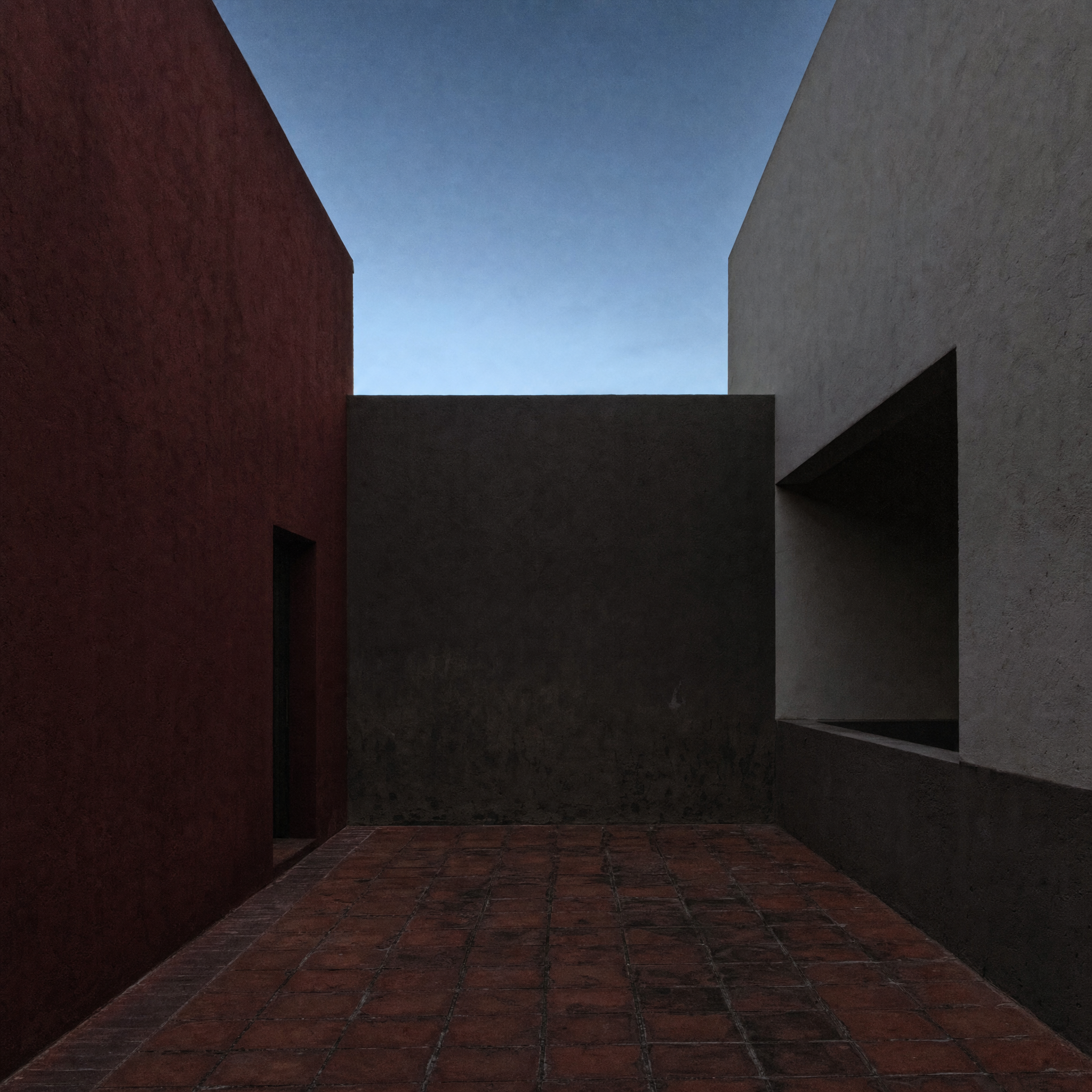 The roof terrace, high plastered walls in red, grey and white cropping the sky, floor of red clay tile