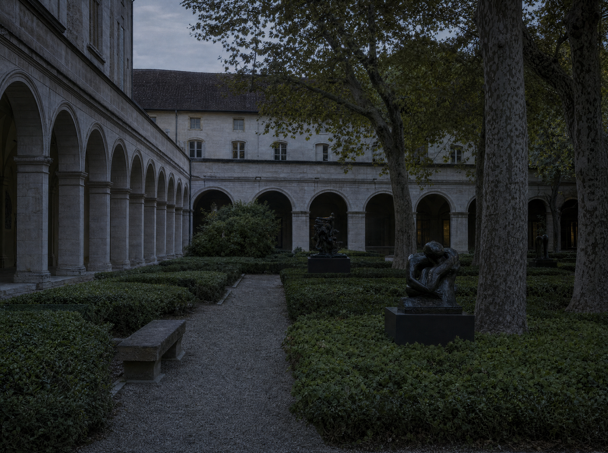 The cloister garden of the former abbey, hedges, gravel and bronze sculpture under evening light