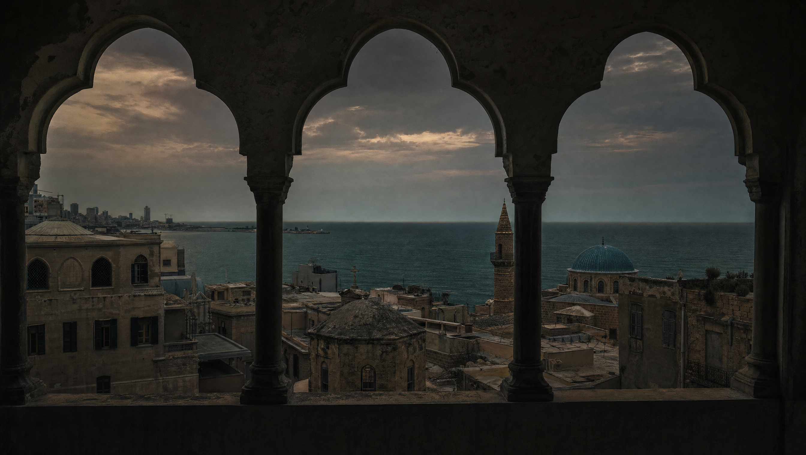 Beirut rooftops and the Mediterranean at dusk, seen past arched windows