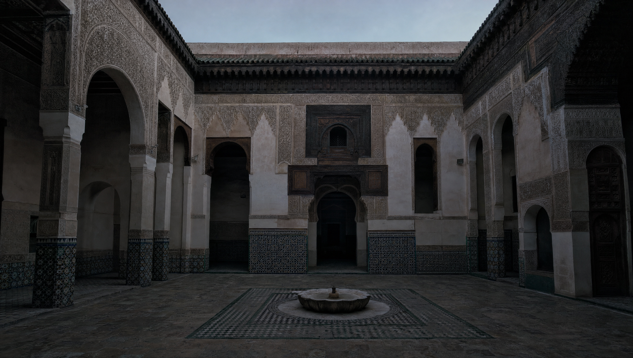 The open courtyard of Dar Si Said at first light: carved stucco, a zellij dado, and a low marble fountain basin