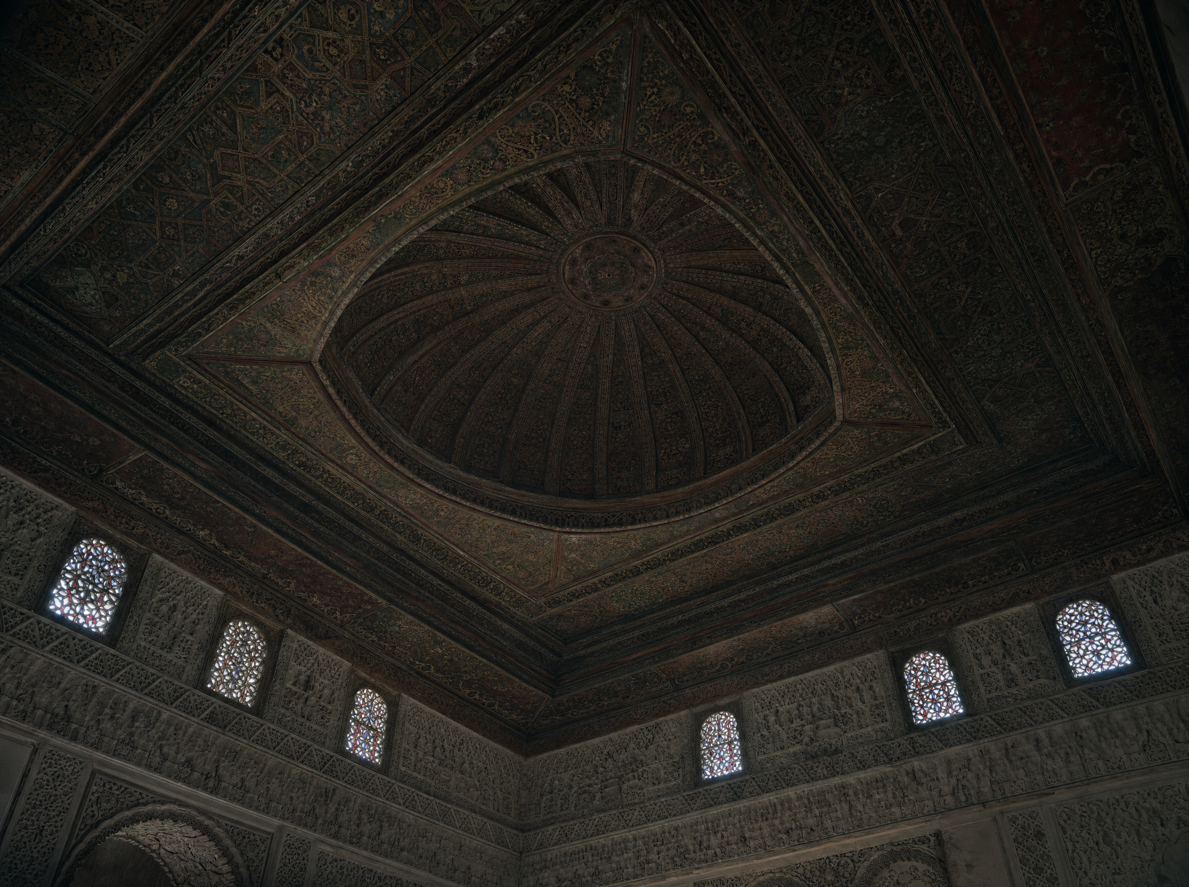 The carved cedar dome of the upstairs reception room, with pierced plaster and small coloured windows below