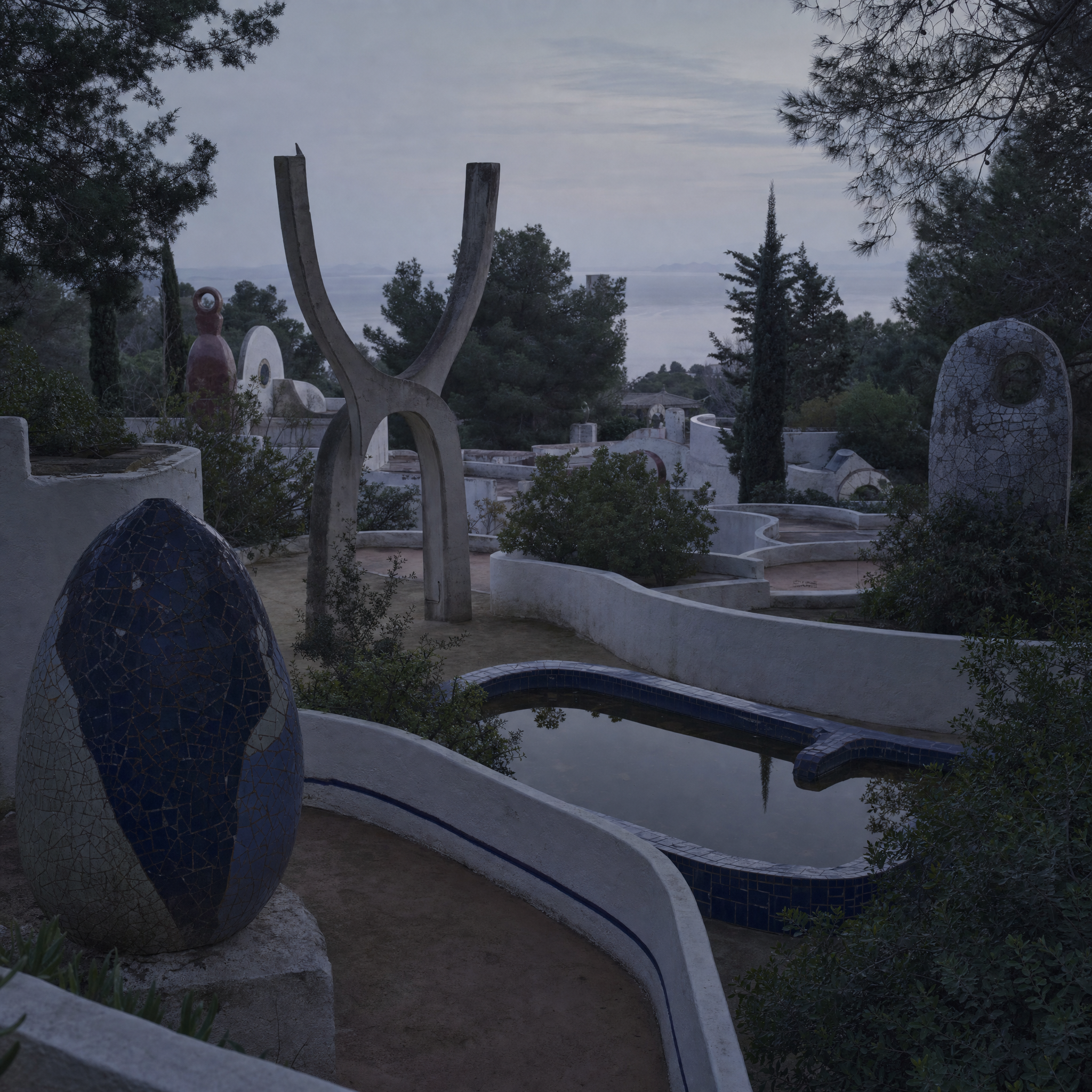 Terraced ceramic and concrete sculptures on a Mediterranean hillside with a tiled water basin at dusk