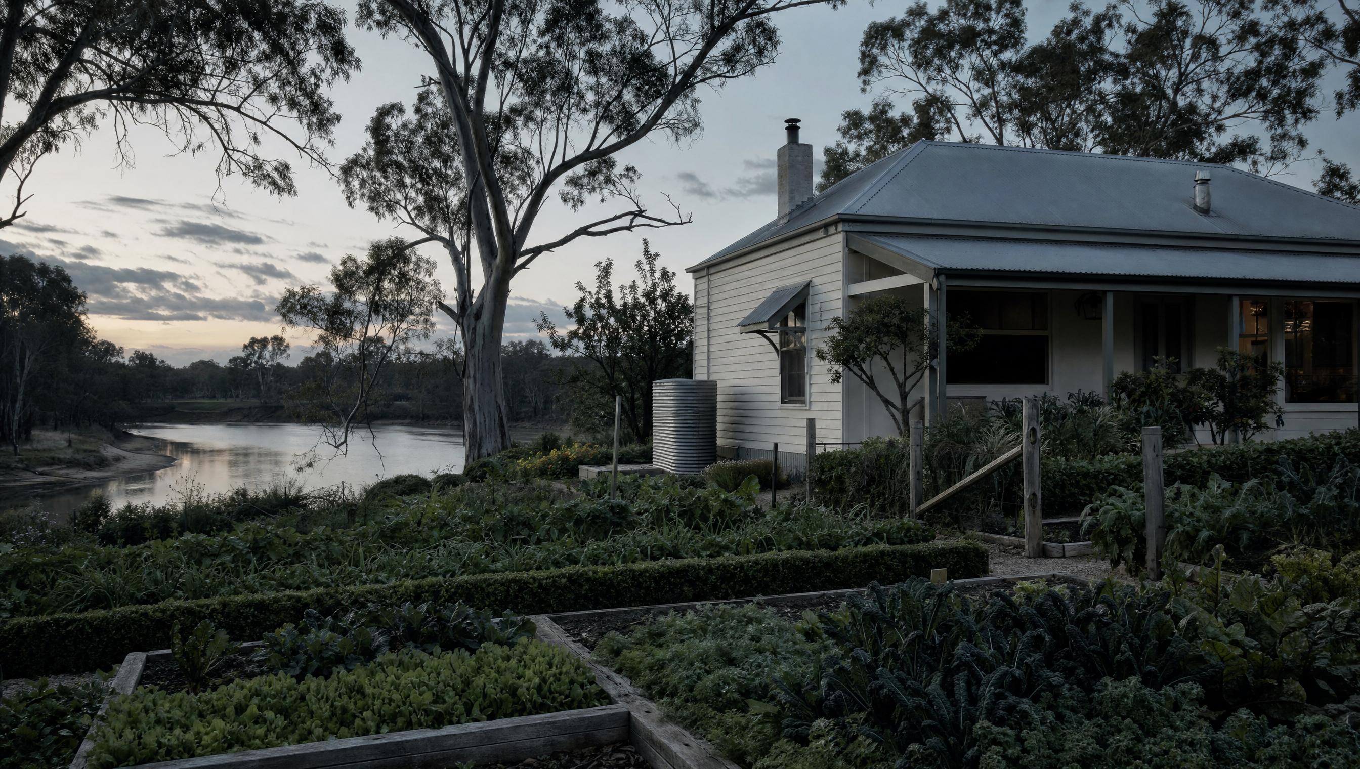 A kitchen garden and modest farmhouse on a river bend among gum trees at dusk