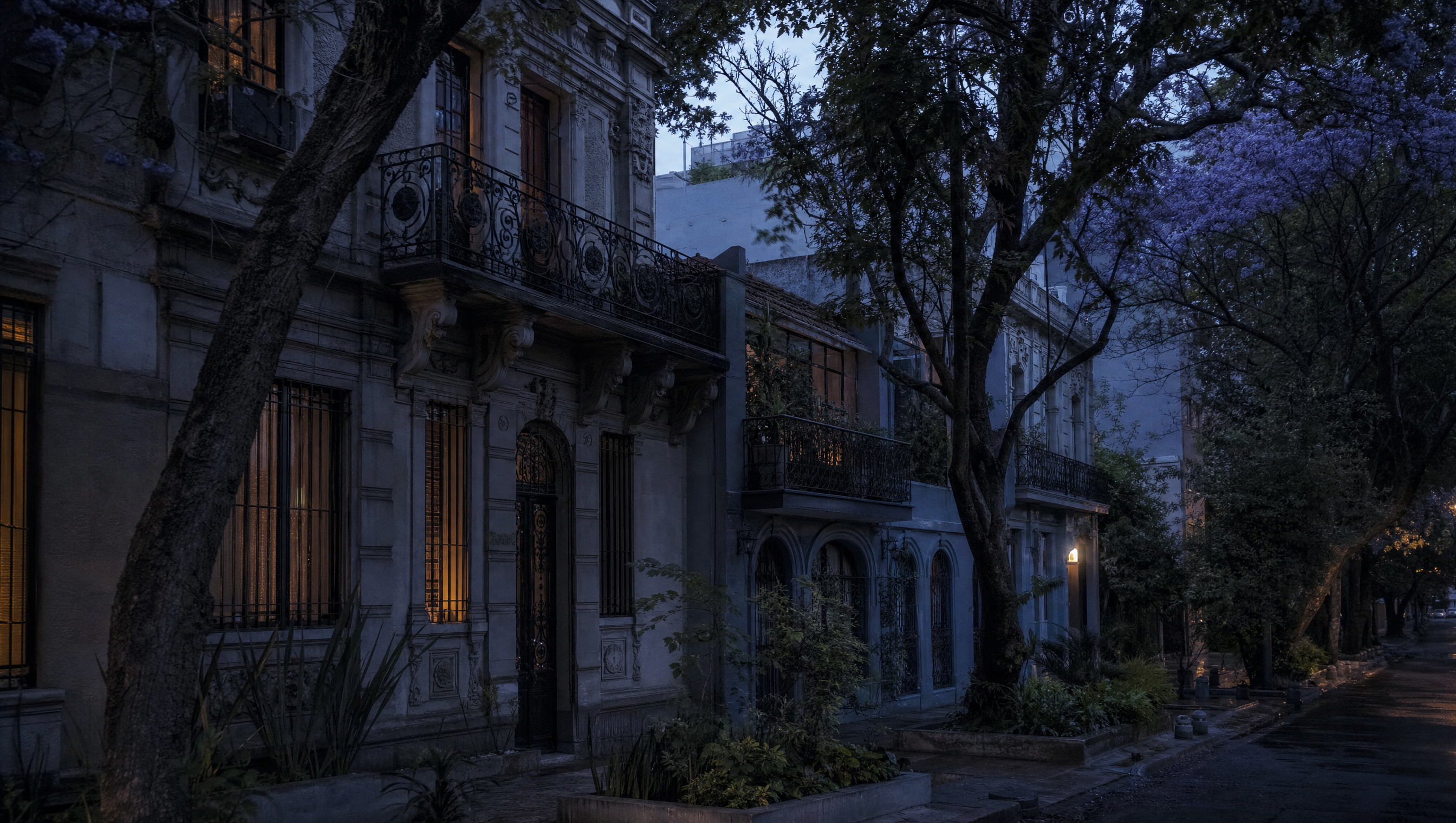 A street of early twentieth-century townhouses at dusk, jacaranda branches over wrought-iron balconies