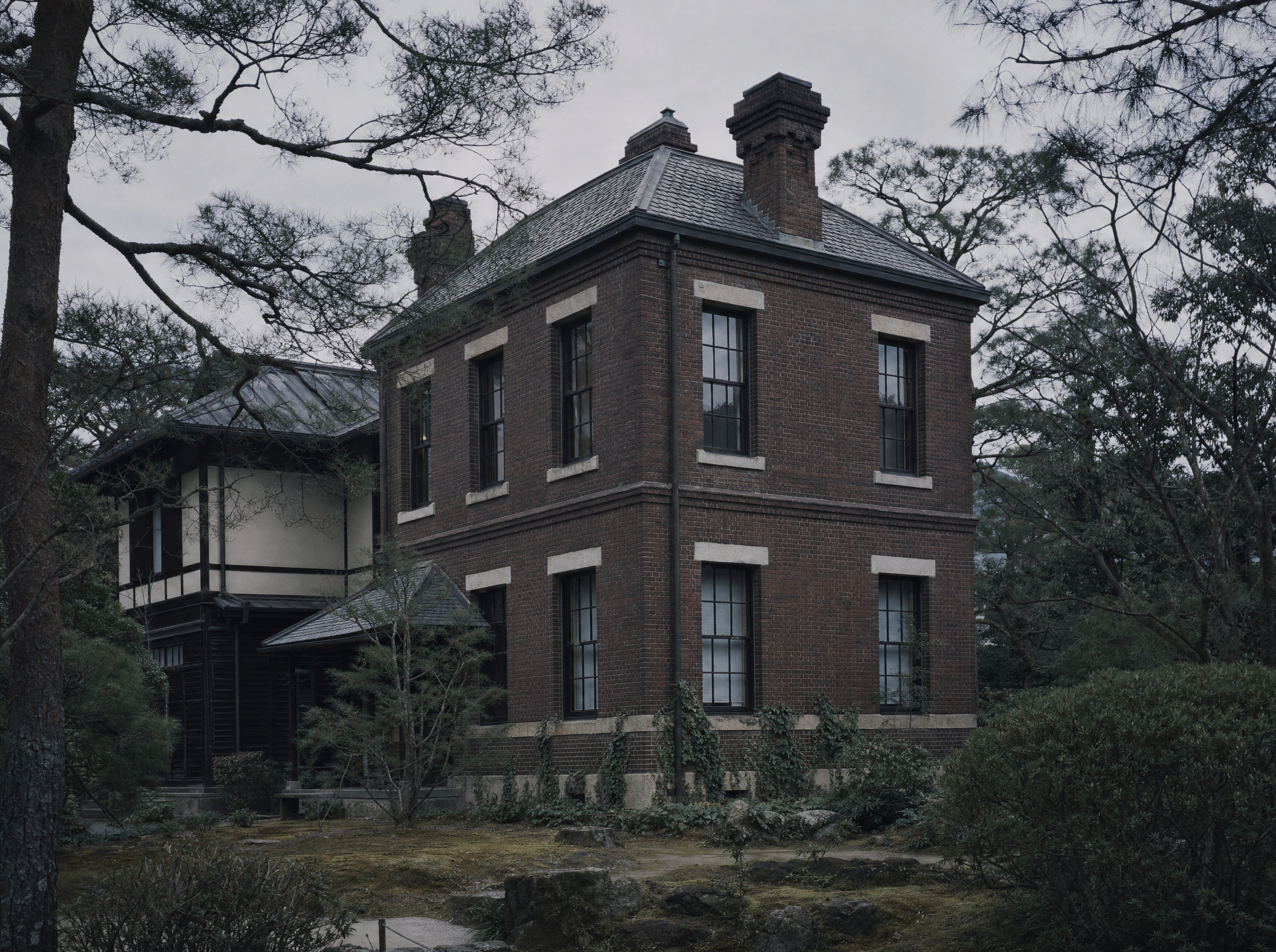 The two-storey brick Western annexe among the garden trees
