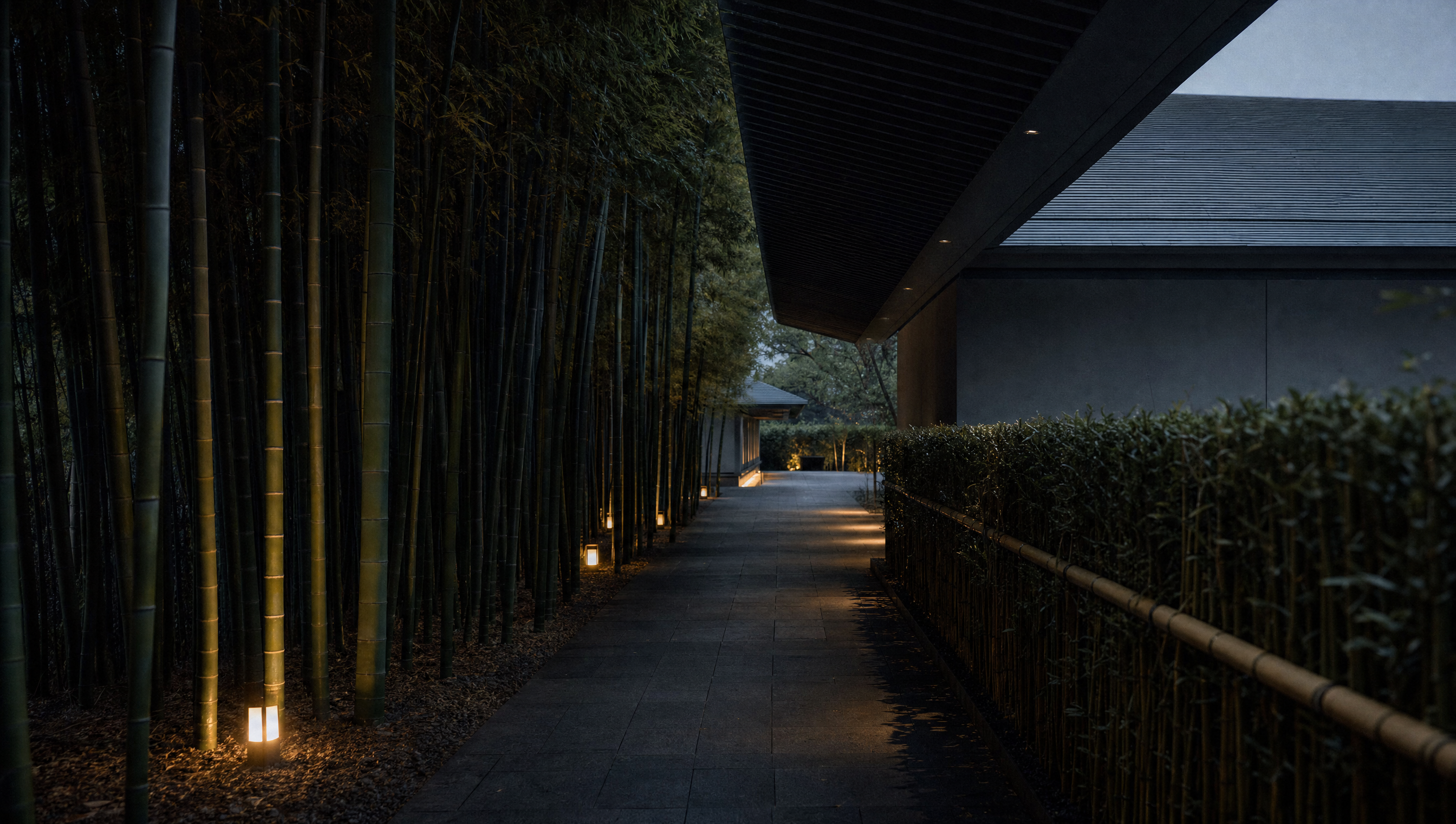 The bamboo-lined approach to the Nezu Museum under its deep tiled eave at dusk