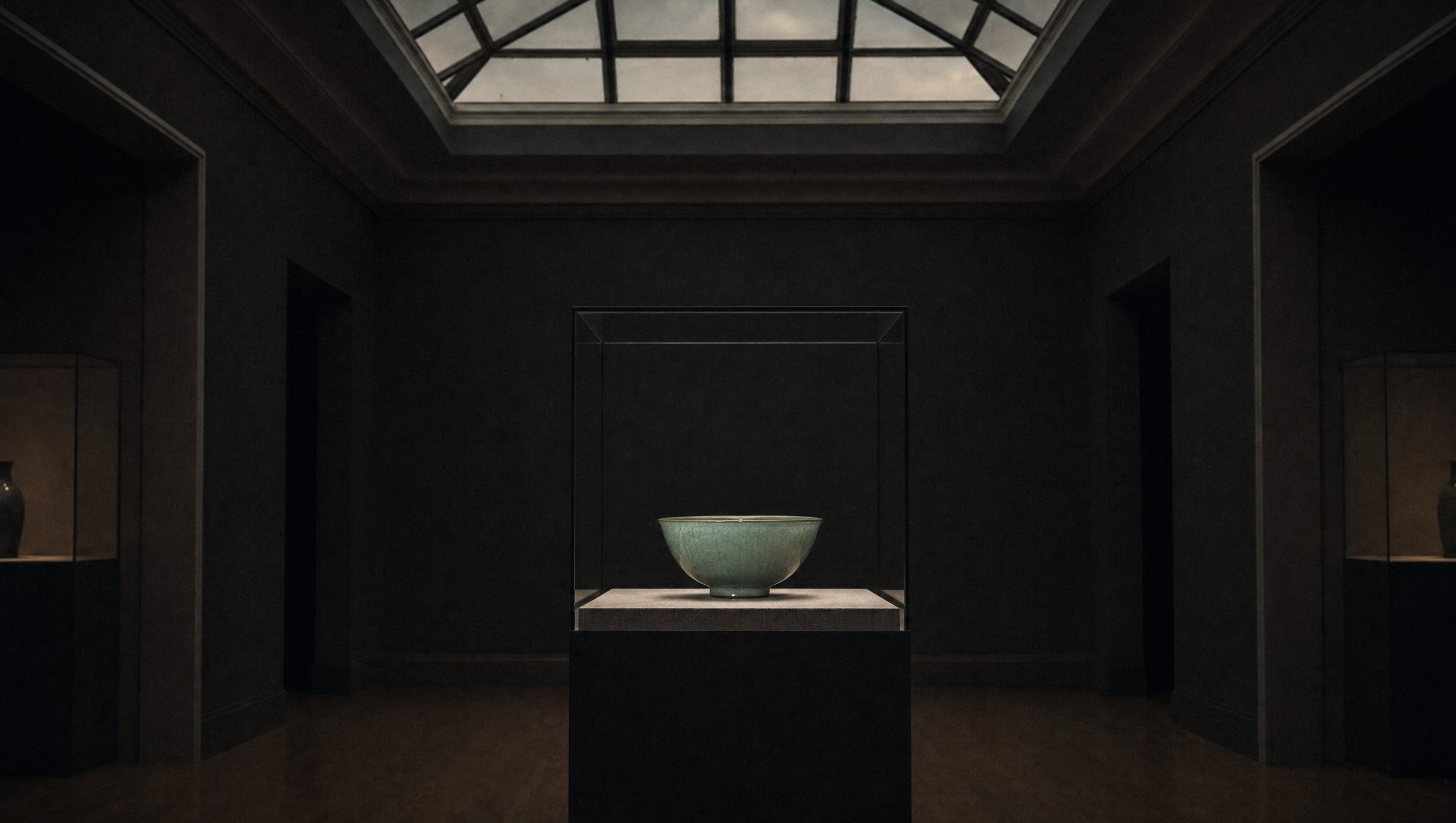 A ceramics gallery, one celadon bowl in a case lit entirely by soft natural daylight, dark walls and deep shadow