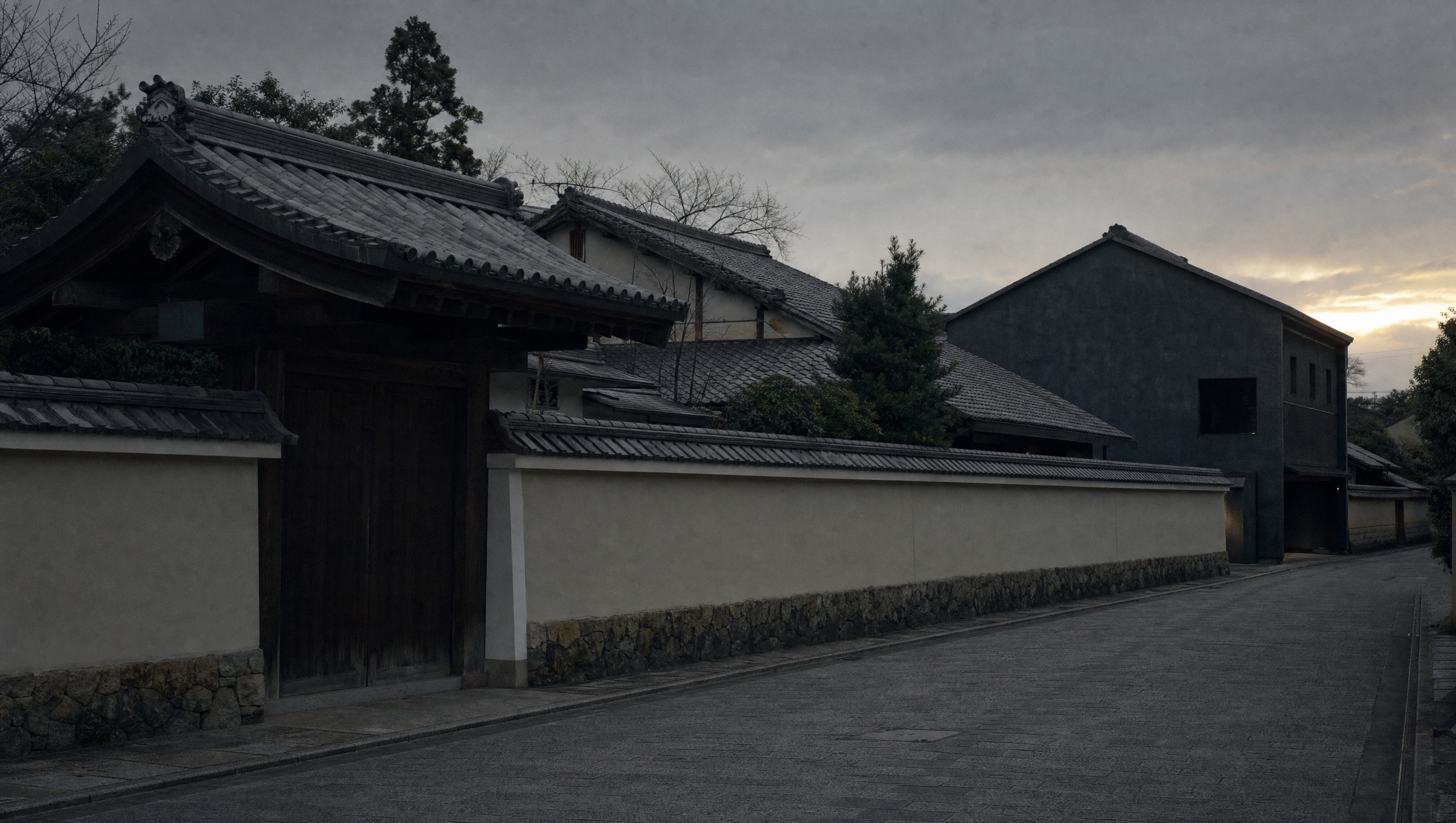 The plastered walls and tiled roofs of the Raku family's street in Kamigyō at dusk