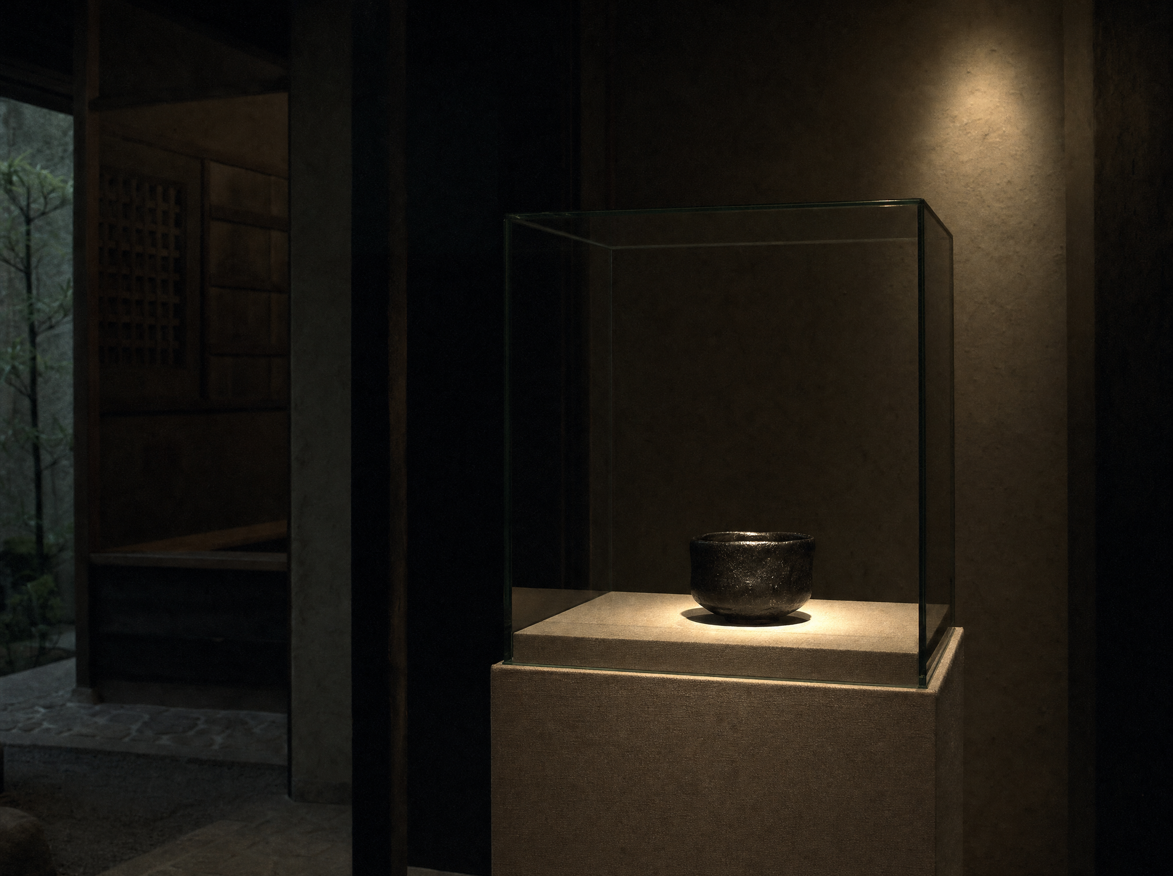 A single black raku tea bowl alone in a lit case