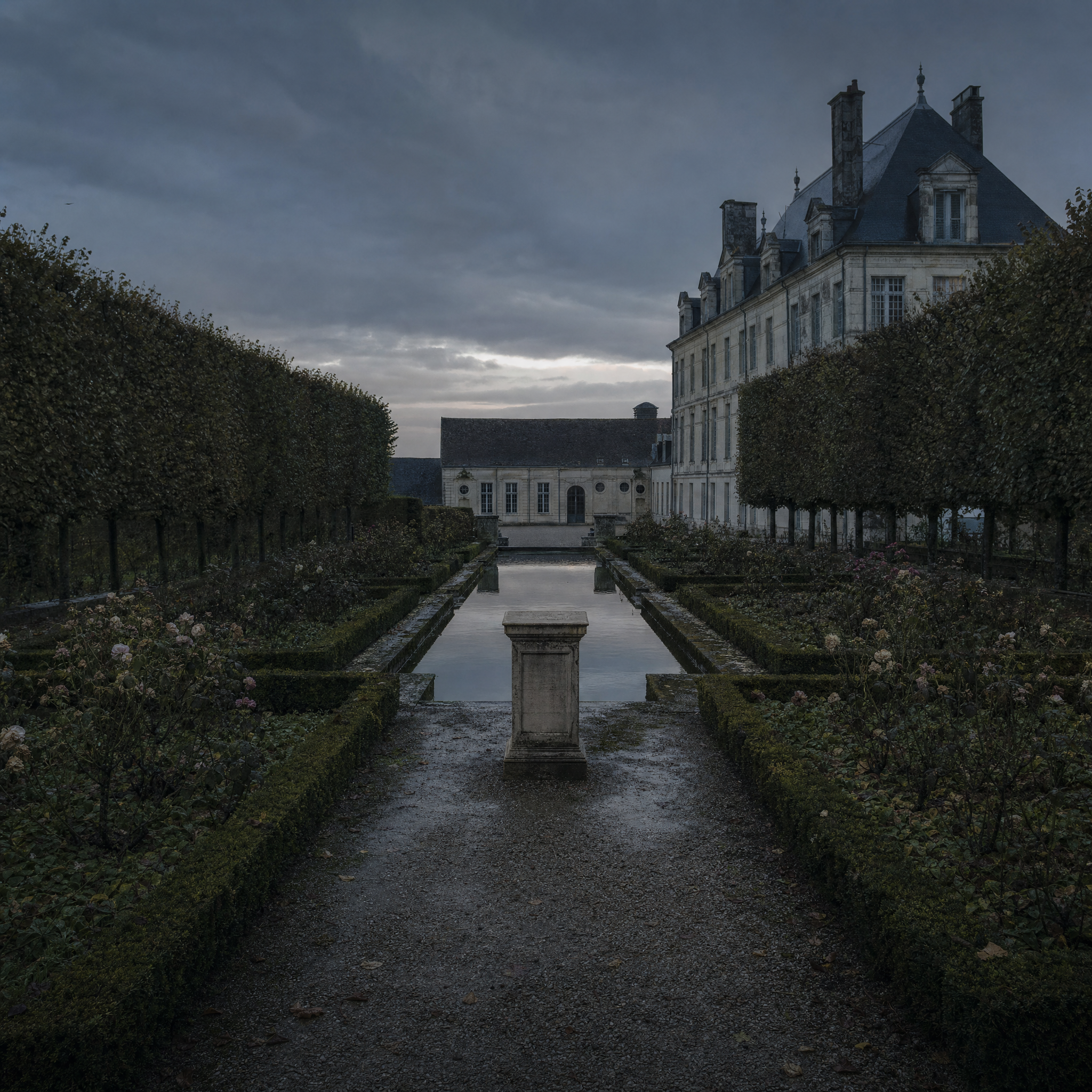 The garden behind the Hôtel Biron at dusk, gravel walks and clipped hedges