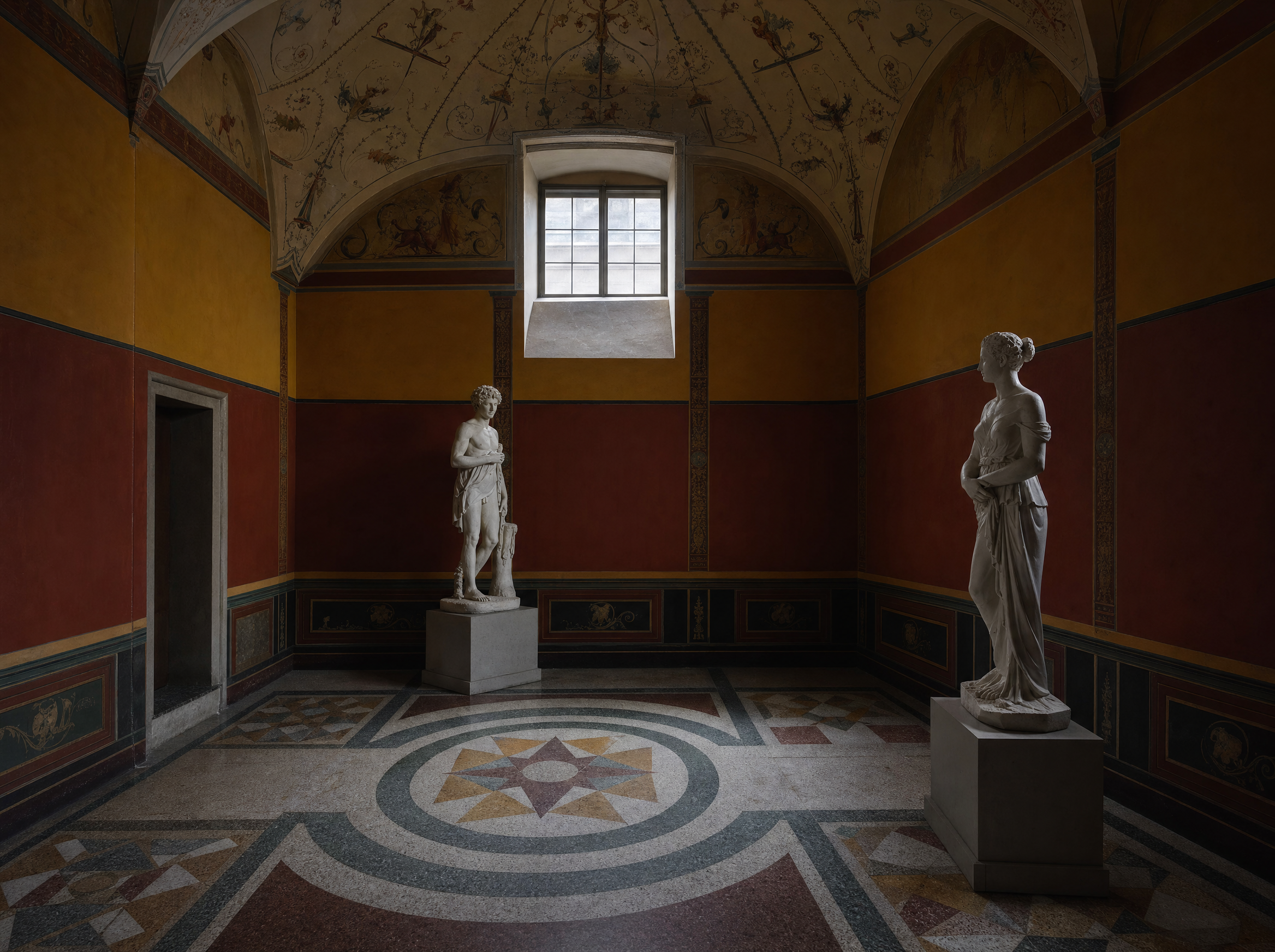 A small vaulted ground-floor chamber, deep ochre walls, white plaster figures, mosaic floor