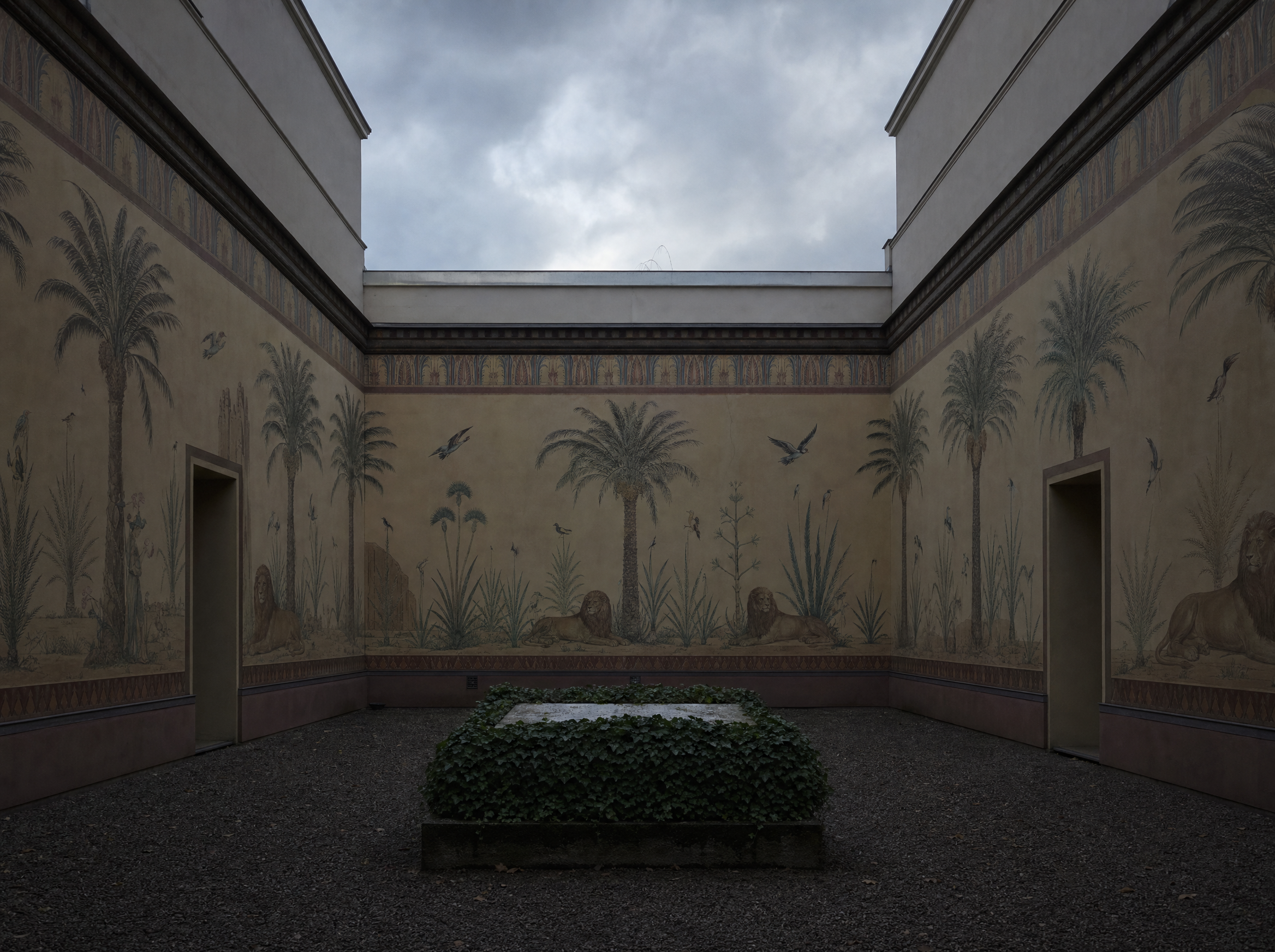 The inner courtyard with its painted walls and the grave slab at the centre